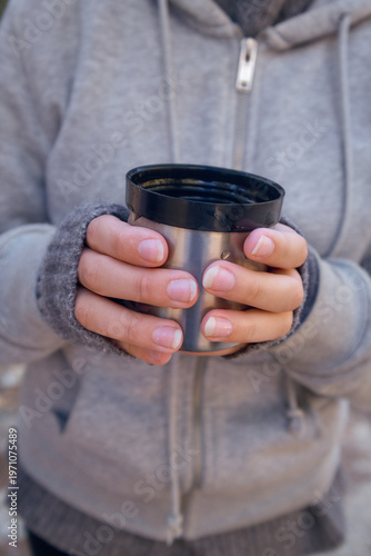 close-up of a thermos cup in his hands