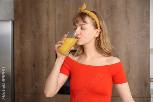 Young woman drinking orange...