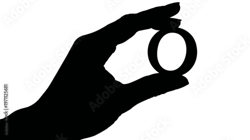 Silhouette of a human hand holding a small circular ring object between fingers, isolated on a clean white background.