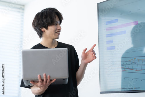 オフィスでパソコンを使って仕事をする若い男性エンジニア