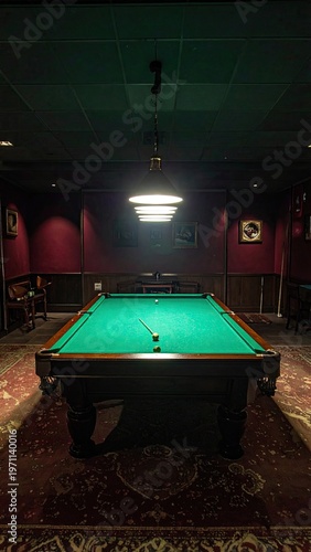 Billiard table with balls and cue stick under warm pendant lighting in a vintage room creating a relaxing atmosphere for leisure and competitive play