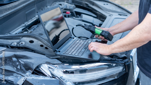 mechanic man at auto service using check up device