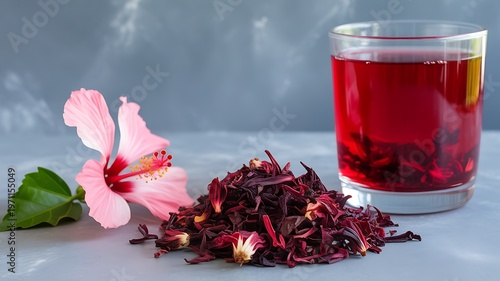 A glass of red tea with flowers and leaves