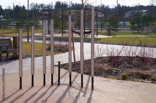 Metal chimes standing in park on sunny day