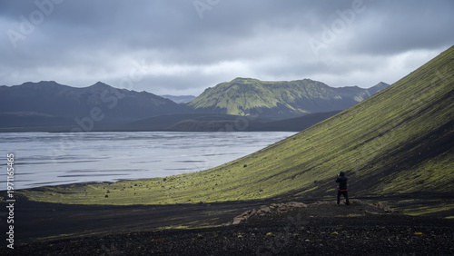 Man photographing glacial landscape with mountains and glacial river, Iceland