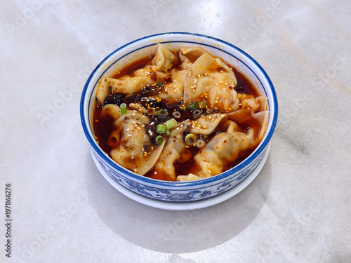 steam hong you dumpling Xiao long bao Shanghai small meat wanton in bowl with mala spicy chilli vinegar on white marble table dim sum halal food breakfast menu for china Hong Kong cafe