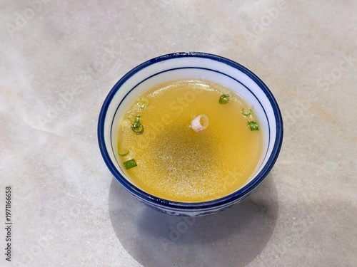 double boiled hot healthy chicken clear soup with spring onion in ceramic chinese classic bowl on white marble table dim sum halal food breakfast menu for china Hong Kong cafe