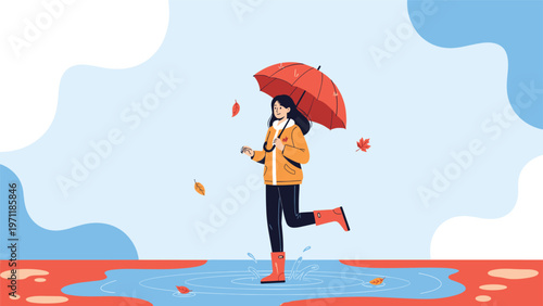 Happy woman in a yellow raincoat and red boots jumping in a water puddle with an umbrella on a rainy autumn day in the park.