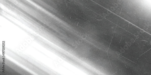 A close up view of a dark metallic surface featuring visible diagonal scratches and light streaks