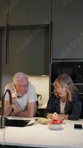 Senior couple enjoying healthy breakfast in modern kitchen
