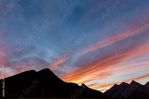 Rugged mountains rises against the horizon across Eastern Iceland as sunset spills across the sky