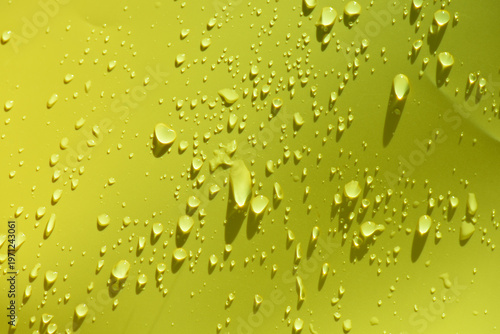 Green water drops with ripples on the surface. Defocus blurred transparent blue colored clear calm water surface texture with splashes and bubbles. Water waves with shining pattern texture background.