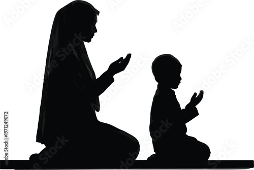 Muslim woman and child praying together in silhouette
