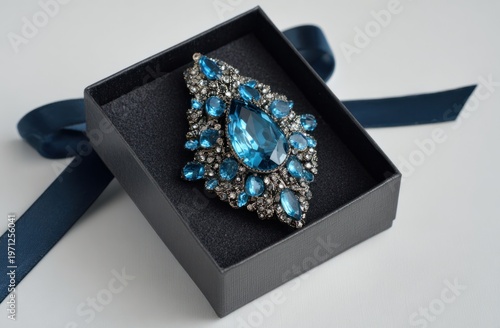 Elegant blue brooch with sparkling crystals featuring intricate design and glossy finish