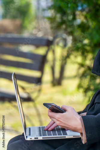Woman holding smartphone and laptop with top copy space for cybersecurity banner