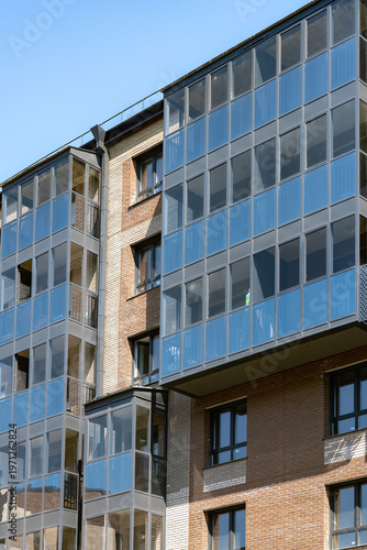 Modern Glass Balcony Apartment Building Facade With Brick Exterior and Urban Windows