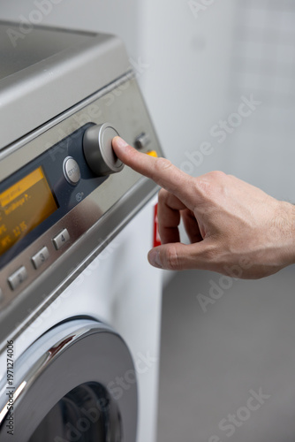 man putting a washing machine to washing machine