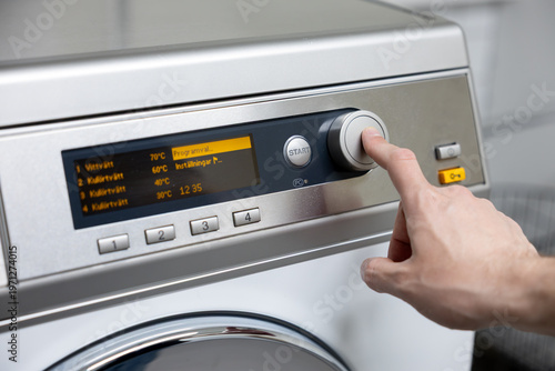 man putting a washing machine to washing machine