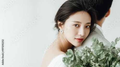 Elegant korean woman with traditional hair style and subtle makeup embracing in a light setting