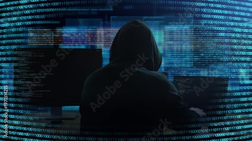 Cyber Hacker Activity. Shadowy Person Monitoring Systems Through Glow Of Multiple Monitors And Code