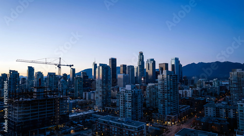Urban skyline at dusk with towering high-rise buildings and construction cranes in dense cityscape