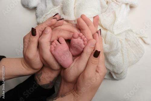 Parents' Hands Gently Holding Newborn Baby's Tiny Feet