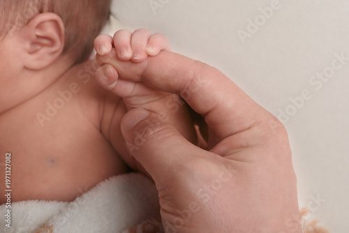 Newborn Baby's Hand Holding Adult's Finger