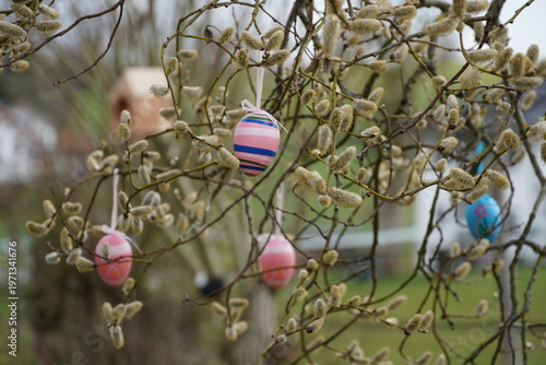 colorful eggs hang from palm branches.