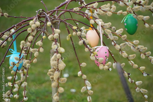 colorful eggs hang from palm branches.