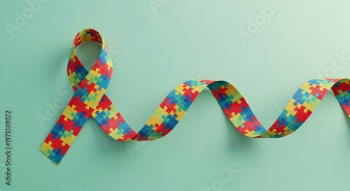Autism awareness ribbon with puzzle pieces on a light green background symbolizing support and understanding