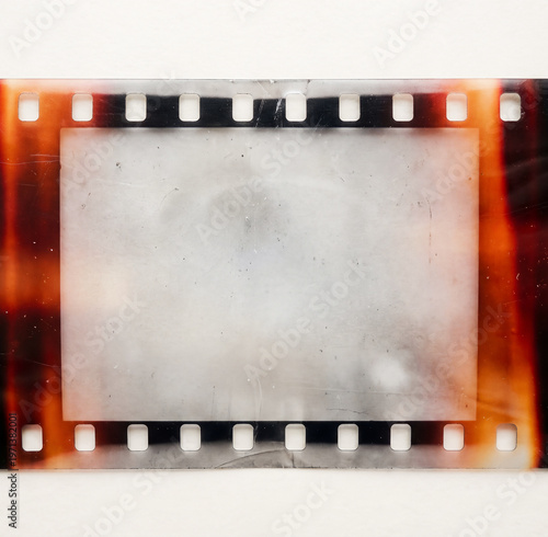 Old 35mm filmstrip or dia slide frame with burned edges isolated on white background. Real analog film scan with signs of usage and light leaks.