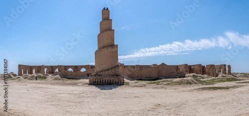 A striking minaret, built with layered brickwork, commands attention against the vibrant blue sky in Abu Dulaf, Iraq