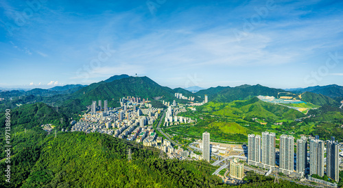 Aerial view of urban landscape nestled in green mountains, Shenzhen, China.