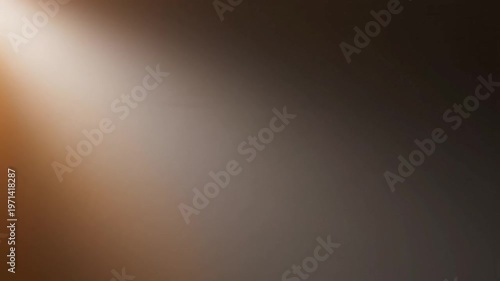 Warm light beam shining on a dark background with a gradient of orange and brown hues.