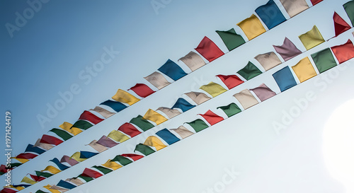 Colorful Tibetan prayer flags fluttering against a clear blue sky