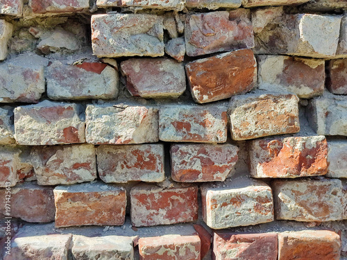 Rough texture background of red brickwork with signs of destruction and wear. Full frame. Close-up