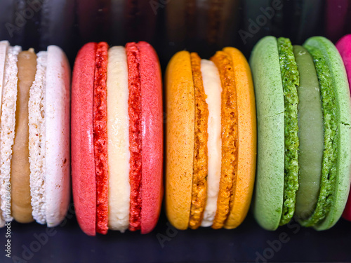 Macaron orange green and red dessert pastry gourmet sweet colorful creamy crunchy filling shell baking treat snack confection luxury vibrant flavor sugar cookie delicate .