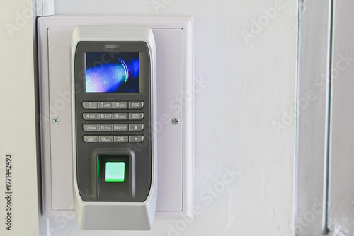 A biometric fingerprint access control device on a wall.