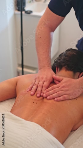 A woman enjoys a soothing back massage with oil at a spa salon, focusing on lymphatic drainage for wellness and relaxation.