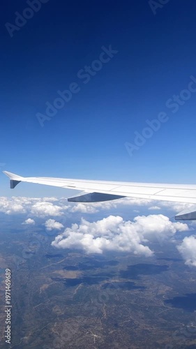 Beautiful European country with big river from above, as seen through airplane window. Passenger POV traveling by air. View of traveler in cabin at plane wing in flight trip with blue sky. 