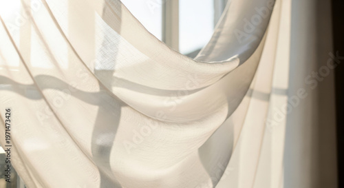 White linen curtain blowing in the breeze by window