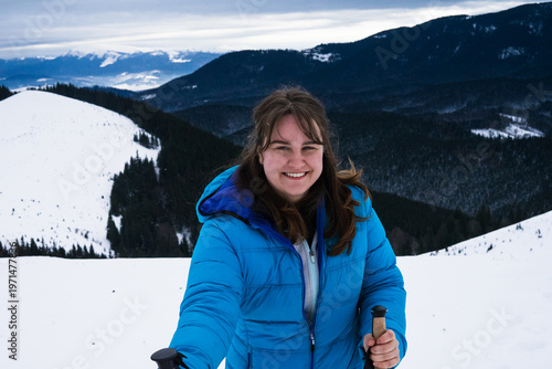 young woman smiling and happy in winter mountains, white snow and forest, ski resort vacation