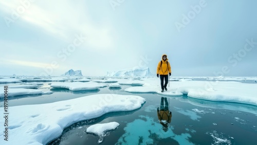 Explorer in yellow jacket walking on floating ice floes in arctic land