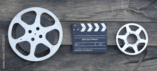 Fotografie movie clapperboard and film strip on a wooden background