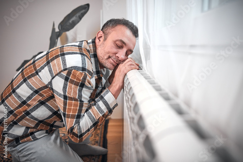 Man heating on a chilly winter day, energy and gas crisis, cold room, heating problems.