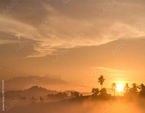 Serene Sunset Over Misty Hills and Silhouetted Palm Trees