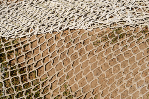 A fishing net is drying on the sand.