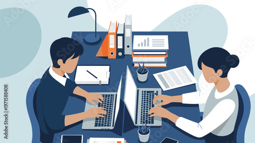 Focused male and female colleagues collaborate on projects using laptops at a shared office desk filled with professional documents.