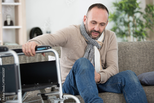 Foto disabled man moving his leg on to the sofa