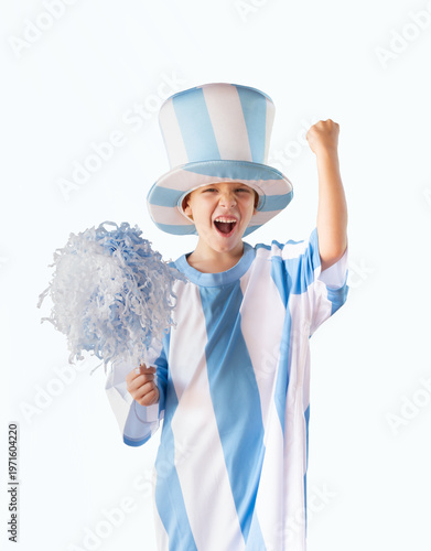 A small boy, a fan of Argentine football, wearing a light blue and white top hat and an Argentine t-shirt